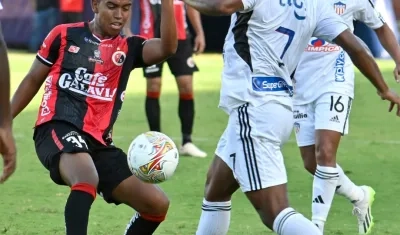 Léider Berrío disputa la posesión de la pelota con Jonathan Tapias.  