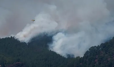 Un helicóptero trabaja en la extinción del incendio forestal en los altos de Güímar.