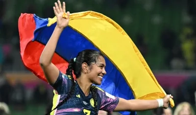 La jugadora colombiana Daniela Arias celebra, con la bandera de su país este martes luego de pasar a cuartos de final