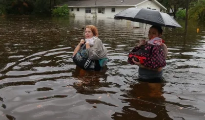 Dos mujeres caminan entre las inundaciones que dejó 'Idalia' a su paso por Florida