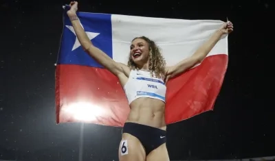 Martina Weil exhibe la bandera chilena tras ganar el oro en los 400 metros.