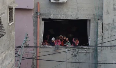 Mujeres y niñas palestinas observan la destrucción provocada por los bombardeos israelíes en el campo de refugiados de Nur Shams