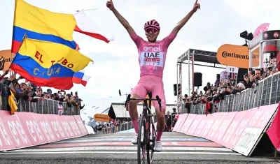 Con el fondo de banderas colombianas, Tadej Pogacar celebra su triunfo en Livigno. 