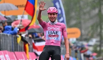 Tadej Pogacar muestra en sumano derecha el número de etapas ganadas en el Giro de Italia. 