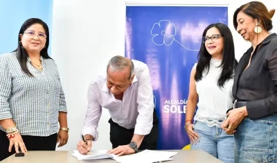 El gerente general de Triple A Ramón Hemer firma la prórroga del contrato en el municipio de Soledad. Lo observa la alcaldesa Alcira Sandoval
