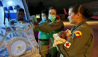 El bebé en manos de personal militar antes de ser ingresado a la aeronave medicalizada.