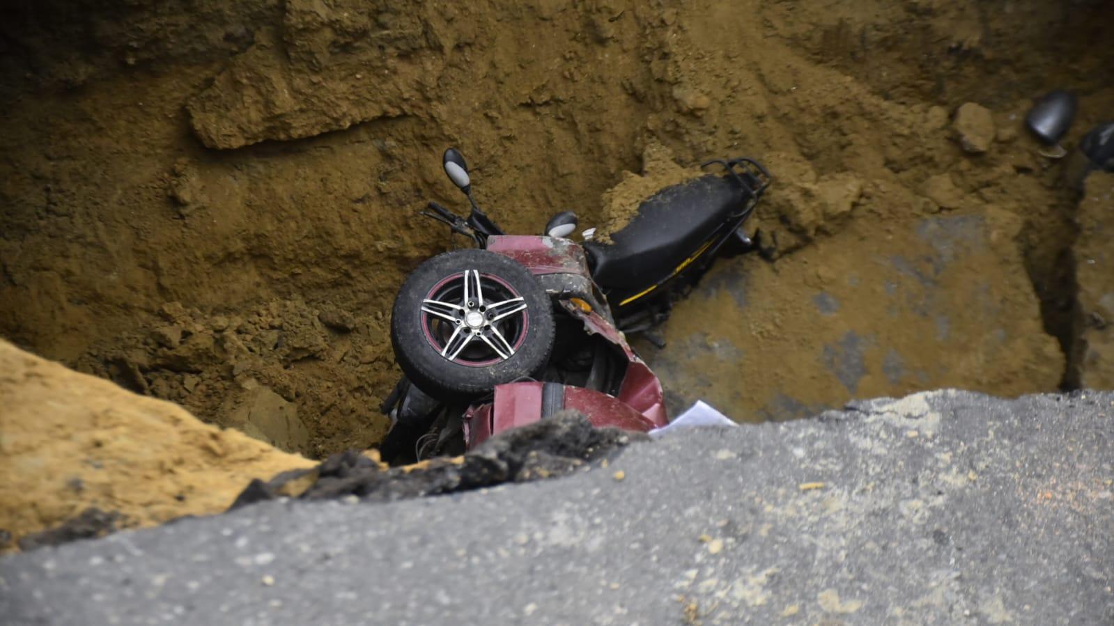 La moto y uno de los vehículos que cayeron al vacío.